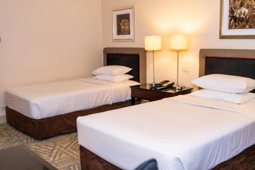 a hotel room with two beds and a table at Royal Majestic Hotel in Johannesburg