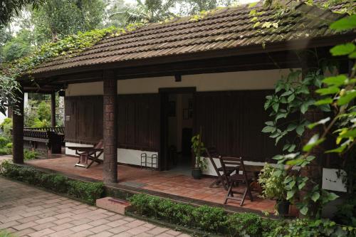 a pavilion with tables and chairs on a patio at Periyaveettil Heritage in Neyyāttinkara