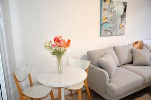 a living room with a table with a vase of flowers on it at Cute Studio Apartment in Maroubra in Sydney