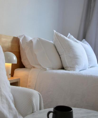 a room with white pillows on a bed at Cute Studio Apartment in Maroubra in Sydney