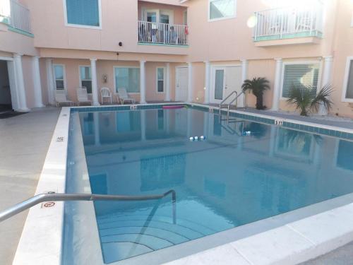 a swimming pool in front of a building at Pineapple Villas in Panama City Beach