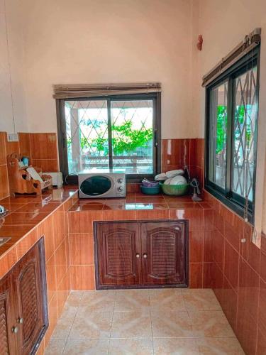 a kitchen with a counter with a microwave and a window at บ้านพักแอบสบาย abbsabyehome in Klong Wan
