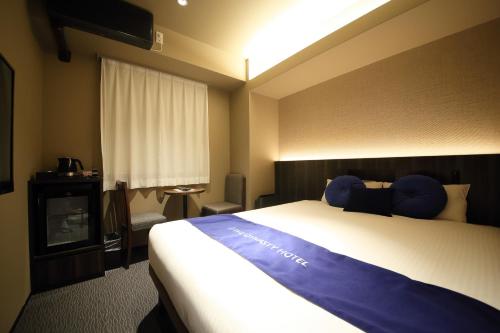 a hotel room with a large bed and a window at Dynasty Hotel & Resort Osaka in Osaka
