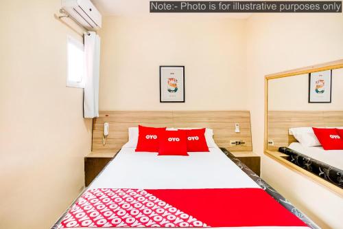 a bedroom with a bed with red pillows at OYO Hotel Itarantim, São Paulo in São Paulo