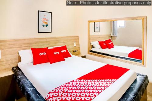 two beds in a hotel room with red pillows at OYO Hotel Itarantim, São Paulo in São Paulo