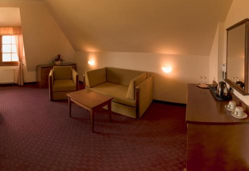a living room with a couch and a table at Hotel VÍTKOVA HORA in Karlovy Vary