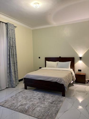 a bedroom with a large bed and a rug at Sunset Hideout Kulambiro in Kampala