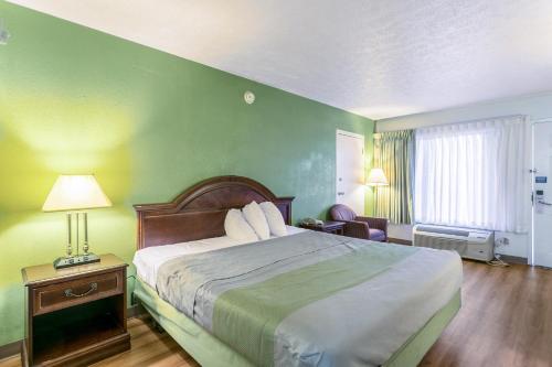 a hotel room with a bed and a green wall at Americas Best Value Inn Edgewood, MD in Edgewood