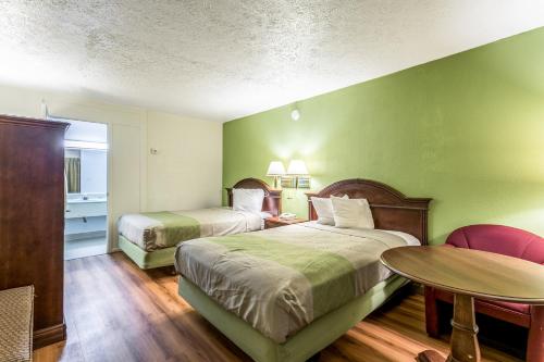 a hotel room with two beds and a table at Americas Best Value Inn Edgewood, MD in Edgewood