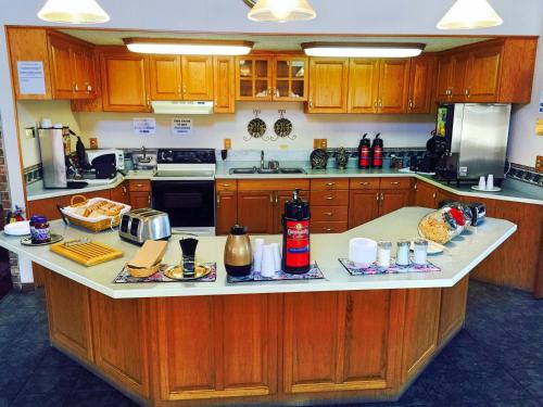 a kitchen with wooden cabinets and a large counter top at HOTEL DEL SOL - Pensacola in Pensacola