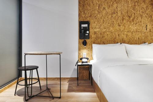 a bedroom with a bed and two stools next to it at Just Sleep Hotel Jihaeng Station in Tongduch'ŏn