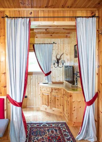 a living room with curtains in a log cabin at Almhütte Tamberger in der Feldpann-Alm in Rauth
