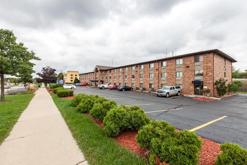 a parking lot next to a brick building at Motel 6-Milwaukee, WI - Glendale in Glendale