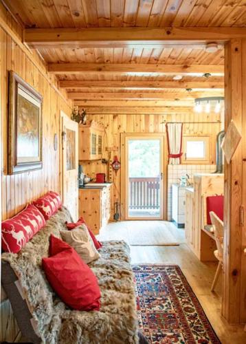a living room with a couch in a log cabin at Almhütte Tamberger in der Feldpann-Alm in Rauth