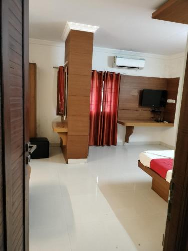 a hotel room with a bed and a television at Sun Classic Residency in Chennai