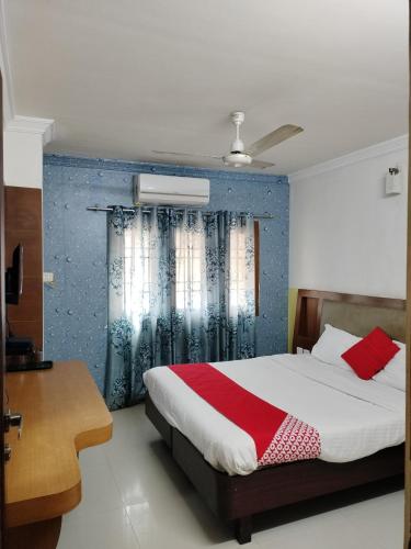 a bedroom with a bed with a blue wall at Sun Classic Residency in Chennai