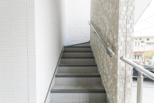 a staircase in a building with a brick wall at Rojuman Hakata in Hakata