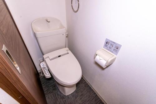 a small bathroom with a toilet and a trash can at Rojuman Hakata in Hakata