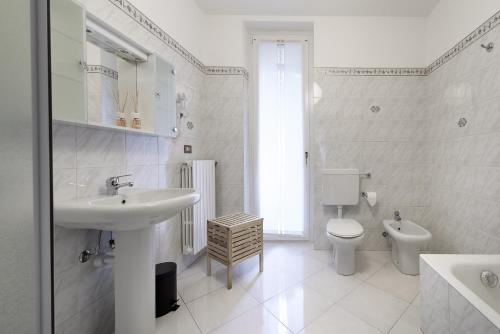 a white bathroom with a sink and a toilet at Bed and Breakfast Sweet Home in Tirano