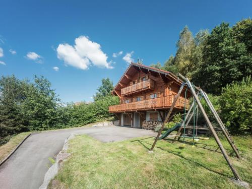 a house with a playground in front of it at Chalet in Vosges with Sauna & Panoramic Views in Anould