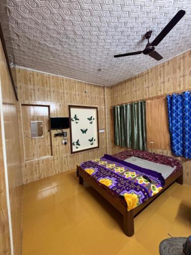 a bedroom with a bed and a ceiling fan at Happy Hills in Yelagiri