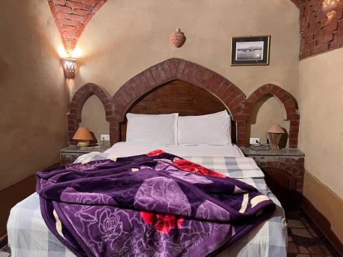 a bed with a purple blanket on top of it at Villa Harmony Luxor in Luxor