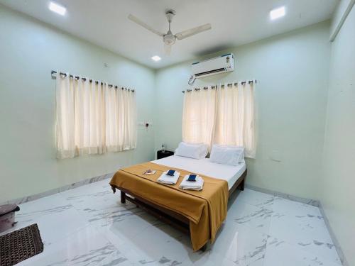 a bedroom with a bed with two towels on it at Book the Entire Villa or Choose a Room for a Comfortable Homestay Experience in Solapur