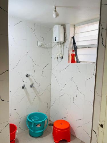 a bathroom with a shower with red and blue stools at Book the Entire Villa or Choose a Room for a Comfortable Homestay Experience in Solapur