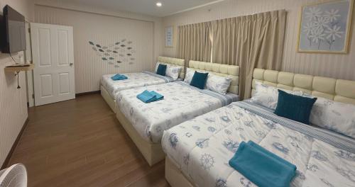 a bedroom with two beds with blue pillows at Sea Flower Onsen in Ban Bo Khaem