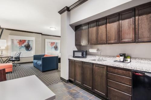 a kitchen with a counter and a living room at Hawthorn Suites by Wyndham Lubbock in Lubbock