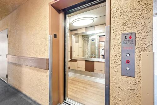 an elevator door in a building with a mirror at Howard Johnson by Wyndham Pasadena in Pasadena