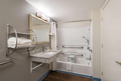a bathroom with a sink and a bath tub at Travelodge by Wyndham Albuquerque West in Albuquerque
