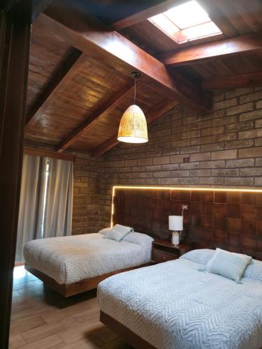 a bedroom with two beds and a ceiling at cabañas el rio alcatraz in Zacatlán