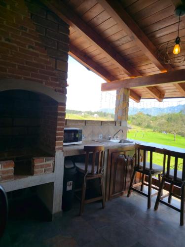 an outdoor kitchen with a counter and a fireplace at cabañas el rio alcatraz in Zacatlán
