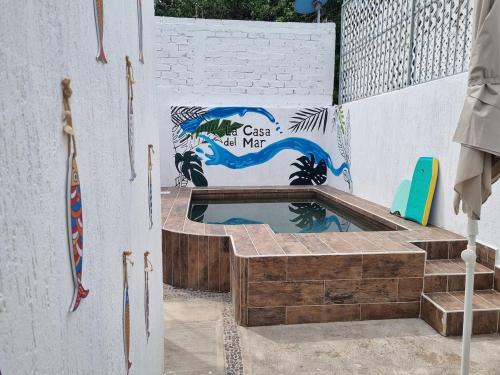 a swimming pool with a painting on a wall at La casa del mar in Manzanillo