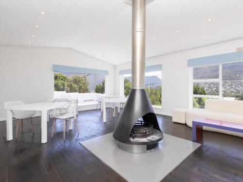 a fireplace in a living room with a table and chairs at Villa Mykonos in Cape Town