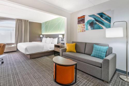 a hotel room with a bed and a couch at Comfort Inn & Suites Madison East Interstate I-90 in Madison