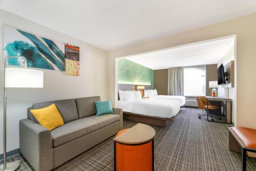 a hotel room with a couch and a bed at Comfort Inn & Suites Madison East Interstate I-90 in Madison