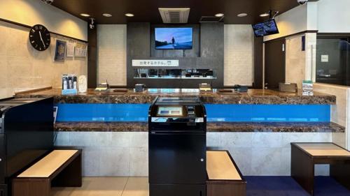a restaurant with a bar with a tv above it at Toyoko Inn Nishi-kawaguchi-eki in Warabi