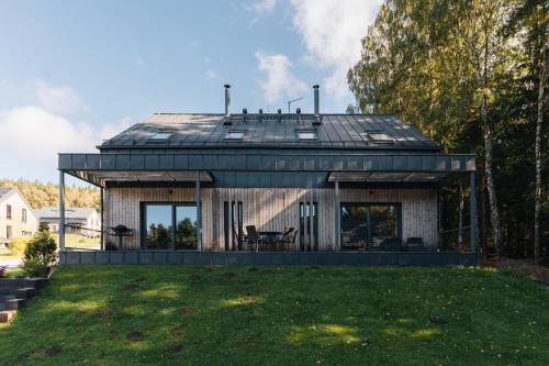 a house with a metal roof on top of a yard at Rezidence U Hájenky 434 in Lipno nad Vltavou