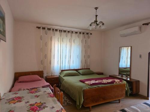 a bedroom with two beds and a window at Garden Home near Osum Canyon & Cooking Experience in Çorovodë
