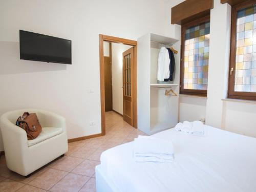 1 dormitorio con 1 cama, 1 silla y TV en Italianflat - Rentroom Verona, en Verona
