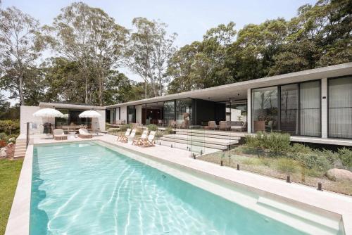 an external view of a house with a swimming pool at Latitude 156 - Elevated Luxury Overlooking the Greens in Doonan