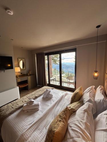 a bedroom with a large bed with towels on it at Evita BelleVue in Arachova