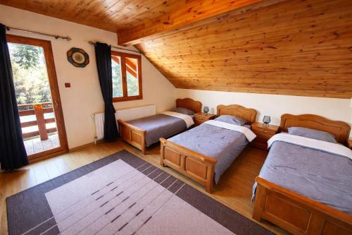 a bedroom with four beds and a wooden ceiling at Orion in Borzont
