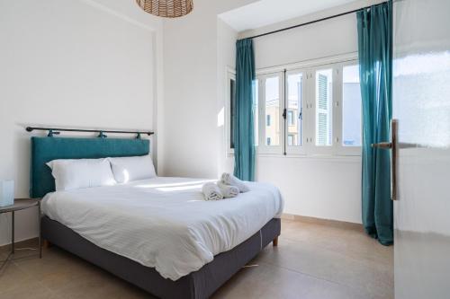 a bedroom with a large bed with blue curtains at Bluewood Retreat|Cozy Vintage 3BDR Nicosia Heart in Nicosia