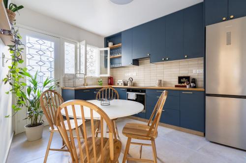 a kitchen with blue cabinets and a table and chairs at Bluewood Retreat|Cozy Vintage 3BDR Nicosia Heart in Nicosia