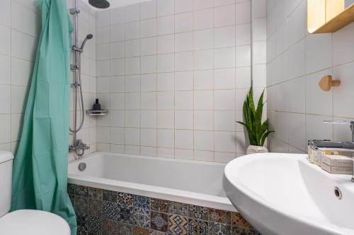 a bathroom with a white tub and a sink at Bluewood Retreat|Cozy Vintage 3BDR Nicosia Heart in Nicosia