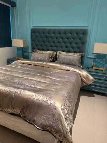 a large bed in a bedroom with a blue wall at The Golfside Luxe in Gonapola