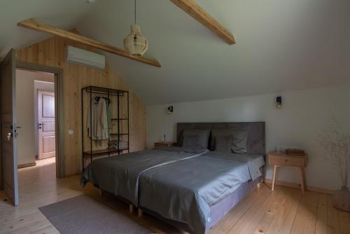 a bedroom with a large bed and a wooden floor at Panekelpių vienkiemis in Aguriškės
